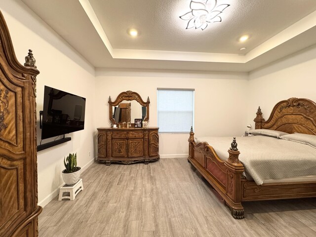 1130 Tangled Orchard Trce, The Acreage, FL 33470 - bedroom featuring a raised ceiling, light wood finished floors, and baseboards