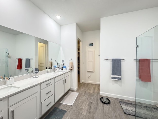 1130 Tangled Orchard Trce, The Acreage, FL 33470 - bathroom with wood finished floors, a shower stall, double vanity, and baseboards