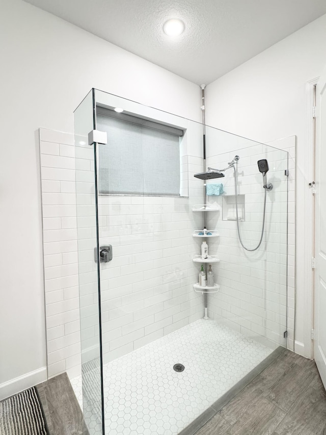 1130 Tangled Orchard Trce, The Acreage, FL 33470 - bathroom featuring a tile shower, wood finished floors, a textured ceiling, and recessed lighting