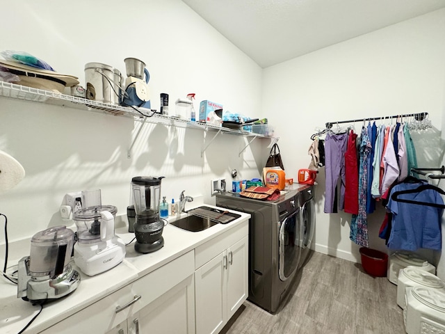 1130 Tangled Orchard Trce, The Acreage, FL 33470 - laundry area with washer and clothes dryer, light wood-style floors, and cabinet space
