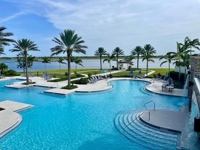 1130 Tangled Orchard Trce, The Acreage, FL 33470 - community pool featuring a patio area, a lawn, and a water view
