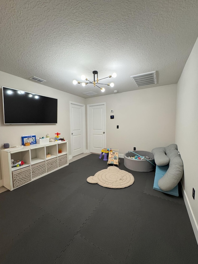 5700 Mentmore Dr, Mangonia Park, FL 33407 - playroom with a chandelier, baseboards, and a textured ceiling