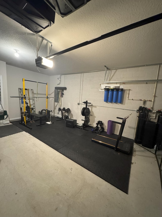 5700 Mentmore Dr, Mangonia Park, FL 33407 - workout area with a garage, a textured ceiling, and concrete block wall