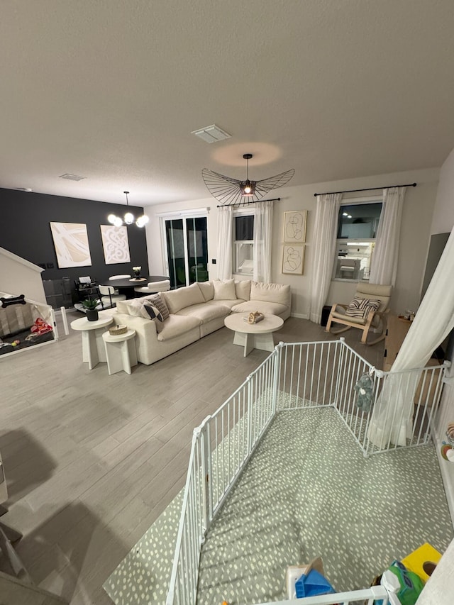5700 Mentmore Dr, Mangonia Park, FL 33407 - living room with wood finished floors, a chandelier, and a textured ceiling