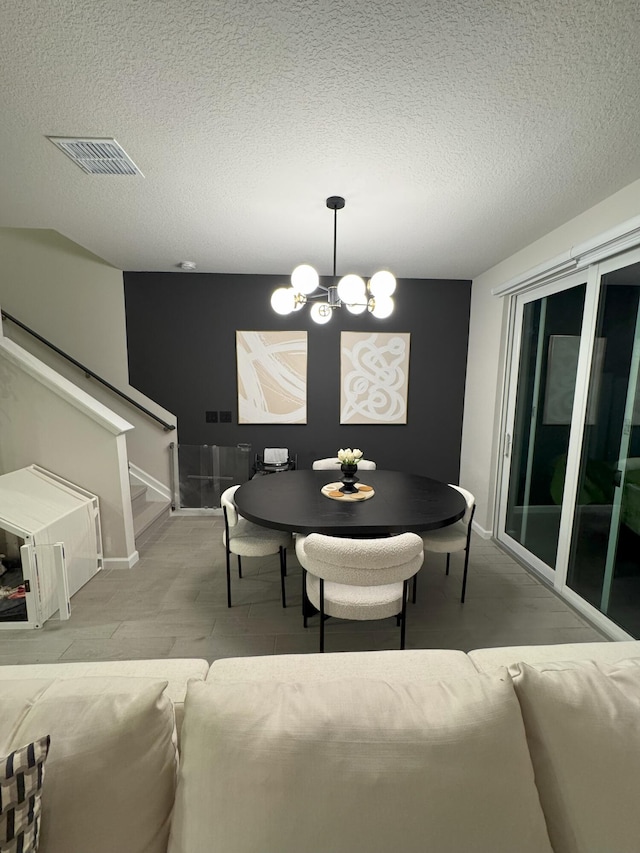 5700 Mentmore Dr, Mangonia Park, FL 33407 - dining room featuring a chandelier, baseboards, wood finished floors, stairway, and a textured ceiling