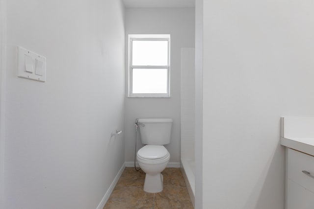 545 SW Buswell Ave, Port Saint Lucie, FL 34983 - bathroom featuring toilet, vanity, a shower, and baseboards