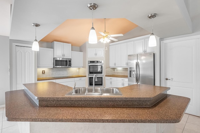 1501 SW Kamchatka Ave, Port Saint Lucie, FL 34953 - kitchen featuring stainless steel appliances, light tile patterned flooring, a ceiling fan, decorative backsplash, and vaulted ceiling