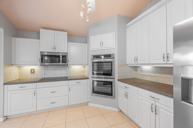 1501 SW Kamchatka Ave, Port Saint Lucie, FL 34953 - kitchen featuring appliances with stainless steel finishes, dark countertops, white cabinets, backsplash, and light tile patterned floors