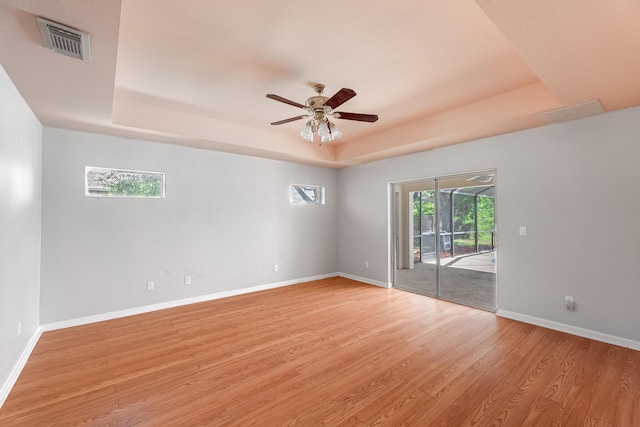 1501 SW Kamchatka Ave, Port Saint Lucie, FL 34953 - spare room with a raised ceiling, light wood-type flooring, and a ceiling fan