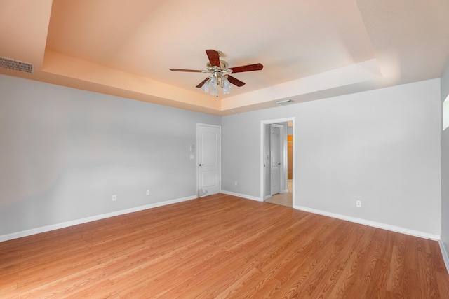 1501 SW Kamchatka Ave, Port Saint Lucie, FL 34953 - unfurnished room featuring a raised ceiling, ceiling fan, and light wood-style flooring
