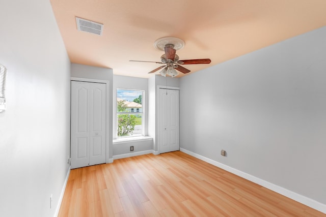 1501 SW Kamchatka Ave, Port Saint Lucie, FL 34953 - unfurnished bedroom with two closets, light wood-style floors, and ceiling fan