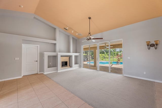 1501 SW Kamchatka Ave, Port Saint Lucie, FL 34953 - unfurnished living room with ceiling fan, light tile patterned floors, rail lighting, high vaulted ceiling, and built in shelves