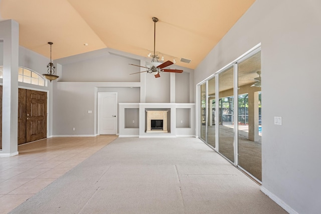 1501 SW Kamchatka Ave, Port Saint Lucie, FL 34953 - unfurnished living room featuring ceiling fan, high vaulted ceiling, tile patterned flooring, a glass covered fireplace, and carpet