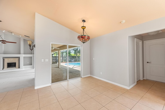1501 SW Kamchatka Ave, Port Saint Lucie, FL 34953 - empty room with ceiling fan, lofted ceiling, light tile patterned flooring, a smoke detector, and a glass covered fireplace