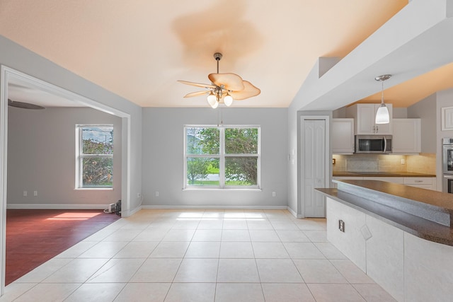 1501 SW Kamchatka Ave, Port Saint Lucie, FL 34953 - kitchen featuring appliances with stainless steel finishes, ceiling fan, light tile patterned floors, backsplash, and hanging light fixtures