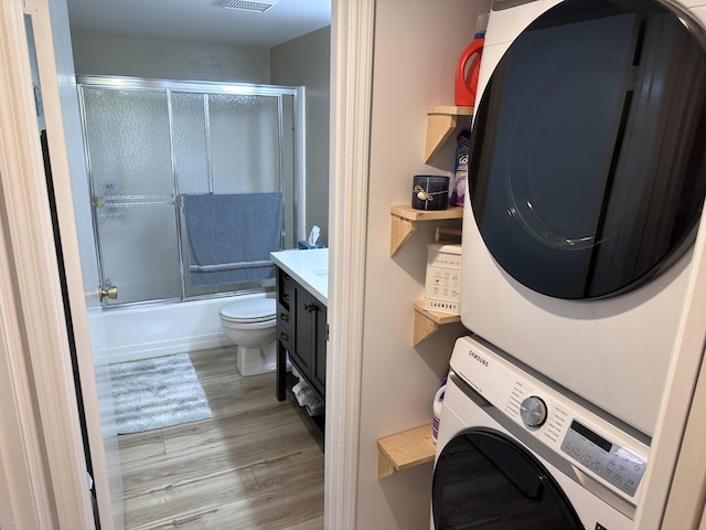 301 SW S River Dr Unit 206, Stuart, FL 34997 - laundry area with stacked washer / dryer and wood finished floors