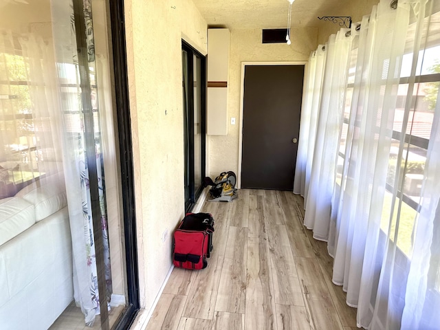 301 SW S River Dr Unit 206, Stuart, FL 34997 - corridor with light wood-style flooring and a textured wall