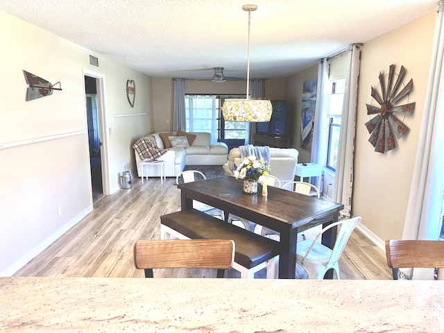 301 SW S River Dr Unit 206, Stuart, FL 34997 - dining space featuring light wood-style flooring, baseboards, and a textured ceiling