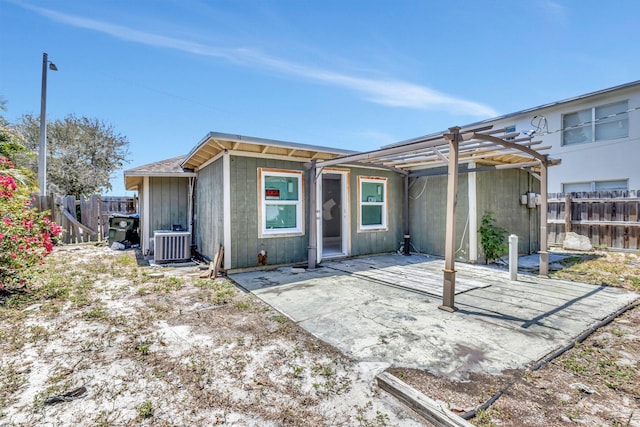 1112 S K St, Lake Worth Beach, FL 33460 - back of house featuring a pergola, a fenced backyard, central AC unit, and a patio