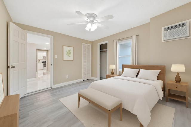 1112 S K St, Lake Worth Beach, FL 33460 - bedroom featuring a wall unit AC, light wood-style floors, baseboards, a ceiling fan, and a closet