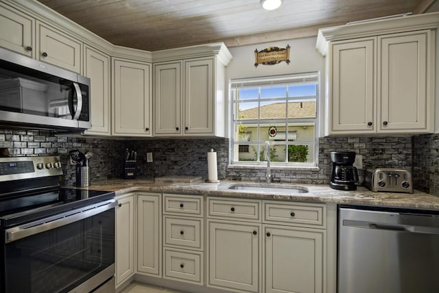 1233 S Lakes End Dr Unit A, Fort Pierce, FL 34982 - kitchen featuring stainless steel appliances, a sink, wood ceiling, tasteful backsplash, and cream cabinetry