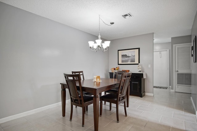 1233 S Lakes End Dr Unit A, Fort Pierce, FL 34982 - dining area featuring a chandelier, a textured ceiling, baseboards, and light tile patterned floors