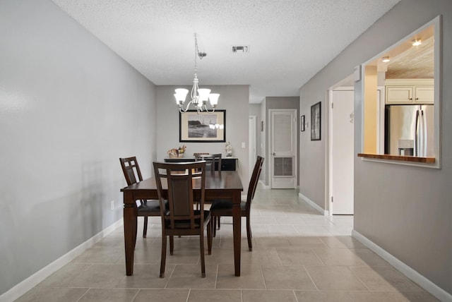1233 S Lakes End Dr Unit A, Fort Pierce, FL 34982 - dining room with a chandelier, baseboards, a textured ceiling, and light tile patterned floors