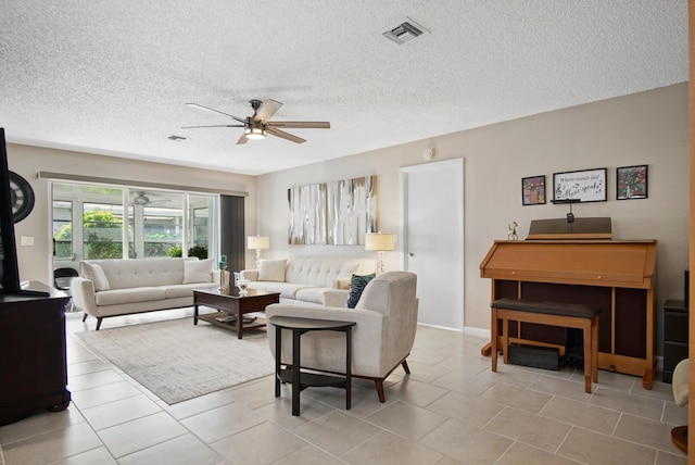 1233 S Lakes End Dr Unit A, Fort Pierce, FL 34982 - tiled living area featuring a ceiling fan and a textured ceiling
