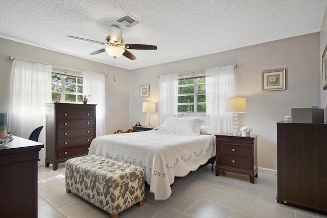 1233 S Lakes End Dr Unit A, Fort Pierce, FL 34982 - bedroom with a textured ceiling, light tile patterned floors, a ceiling fan, and baseboards