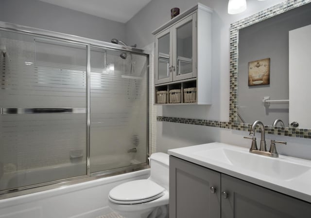 1233 S Lakes End Dr Unit A, Fort Pierce, FL 34982 - bathroom with toilet, vanity, tasteful backsplash, and bath / shower combo with glass door