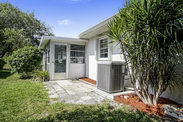 1233 S Lakes End Dr Unit A, Fort Pierce, FL 34982 - property entrance with stucco siding, a yard, and central air condition unit