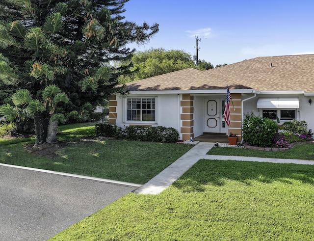 1233 S Lakes End Dr Unit A, Fort Pierce, FL 34982 - ranch-style house with a front lawn, stucco siding, and roof with shingles