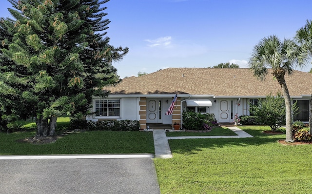 1233 S Lakes End Dr Unit A, Fort Pierce, FL 34982 - single story home featuring a front lawn, a shingled roof, and stucco siding