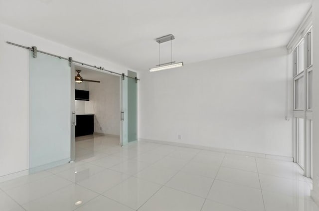 2200 S Ocean Blvd Unit 606, Delray Beach, FL 33483 - unfurnished room featuring a barn door, baseboards, and light tile patterned flooring