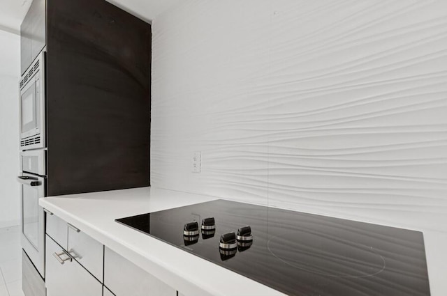 2200 S Ocean Blvd Unit 606, Delray Beach, FL 33483 - detailed view of black electric stovetop, stainless steel microwave, oven, and light countertops