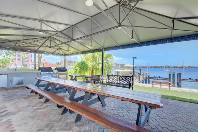 875 E Camino Real Unit 2G, Boca Raton, FL 33432 - wooden deck featuring boat lift, outdoor dining space, a patio area, a dock, and a water view