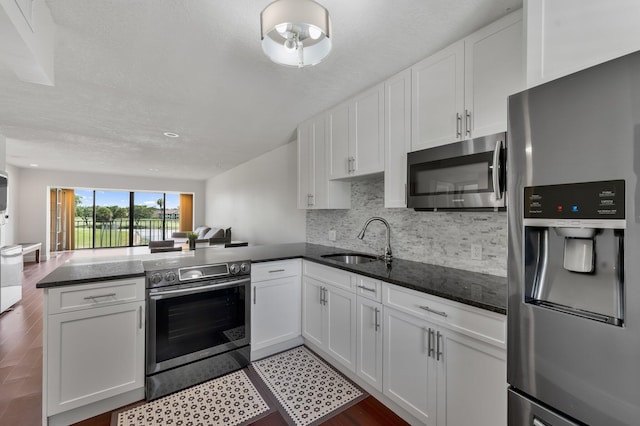 4489 Luxemburg Ct Unit 306, Lake Worth, FL 33467 - kitchen with stainless steel appliances, a sink, a peninsula, open floor plan, and white cabinets