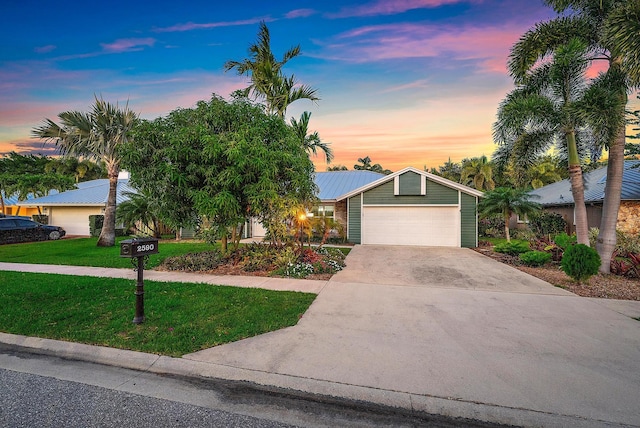 2590 Monaco Ter, Palm Beach Gardens, FL 33410 - view of front of property featuring a lawn, concrete driveway, an attached garage, and metal roof