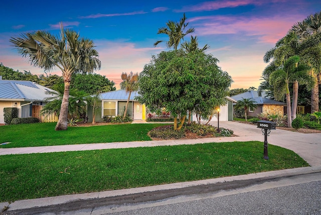 2590 Monaco Ter, Palm Beach Gardens, FL 33410 - view of property hidden behind natural elements featuring a lawn, driveway, metal roof, and an attached garage