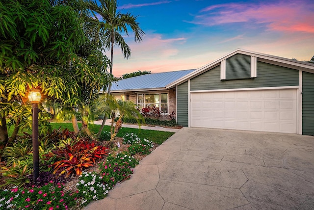2590 Monaco Ter, Palm Beach Gardens, FL 33410 - mid-century home featuring driveway, an attached garage, and metal roof
