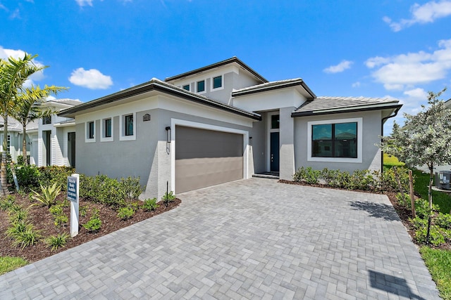 10213 SW Latium Way, Port Saint Lucie, FL 34987 - view of front facade featuring an attached garage, stucco siding, and decorative driveway