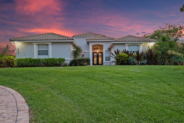 1936 SW Wood Duck Ln, Palm City, FL 34990 - mediterranean / spanish-style home featuring french doors, stucco siding, a tile roof, and a front yard
