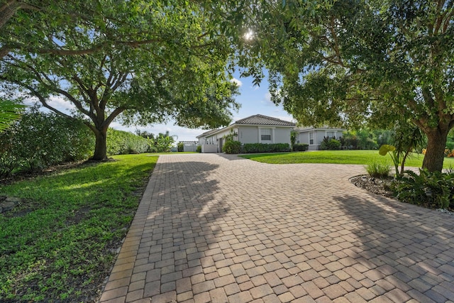 1936 SW Wood Duck Ln, Palm City, FL 34990 - ranch-style house featuring decorative driveway, a garage, and a front yard