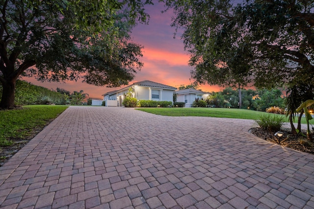 1936 SW Wood Duck Ln, Palm City, FL 34990 - view of front of house featuring curved driveway, a lawn, and an attached garage