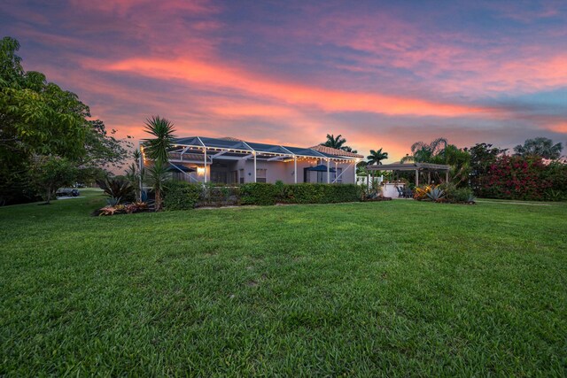 1936 SW Wood Duck Ln, Palm City, FL 34990 - yard at dusk featuring a lawn and a pergola