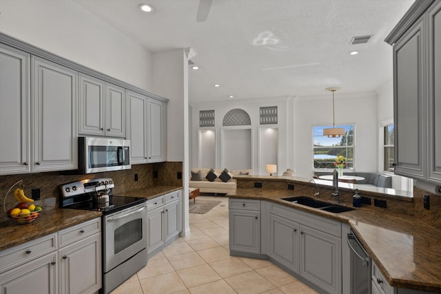 1936 SW Wood Duck Ln, Palm City, FL 34990 - kitchen with appliances with stainless steel finishes, a sink, gray cabinetry, backsplash, and recessed lighting