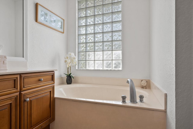 1936 SW Wood Duck Ln, Palm City, FL 34990 - bathroom featuring vanity, a garden tub, and a textured wall