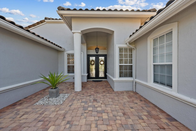 1936 SW Wood Duck Ln, Palm City, FL 34990 - property entrance with french doors, stucco siding, and a tile roof