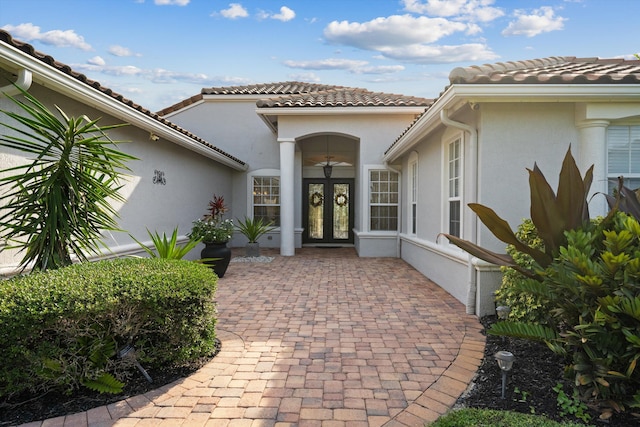 1936 SW Wood Duck Ln, Palm City, FL 34990 - view of exterior entry with french doors, stucco siding, and a tile roof