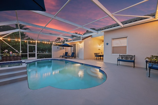 1936 SW Wood Duck Ln, Palm City, FL 34990 - pool at dusk featuring a patio, glass enclosure, and a pool with connected hot tub